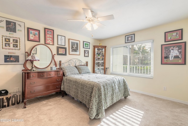 bedroom with light carpet, a ceiling fan, and baseboards