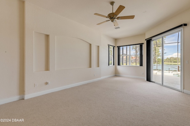 spare room featuring light carpet and ceiling fan