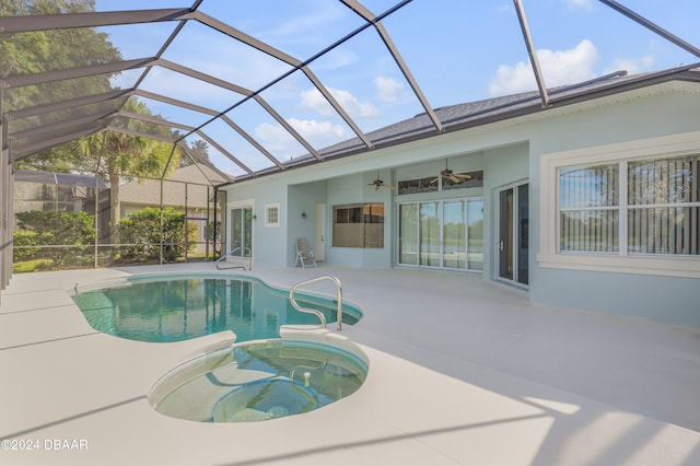 view of swimming pool with a patio, ceiling fan, and glass enclosure