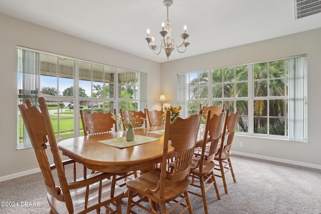 dining space with a healthy amount of sunlight, carpet floors, and a notable chandelier