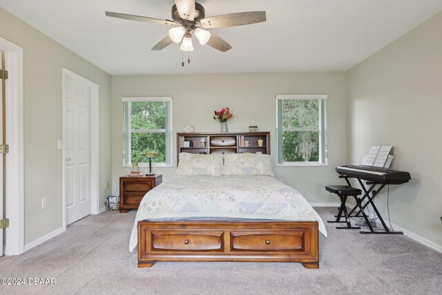 carpeted bedroom featuring ceiling fan and multiple windows