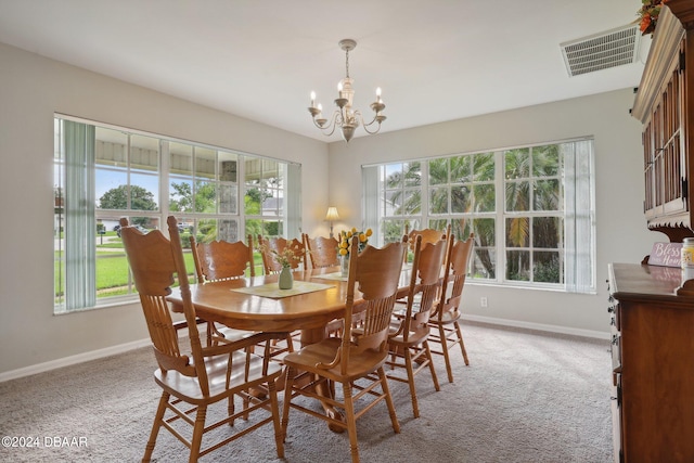 dining space with a notable chandelier and light carpet