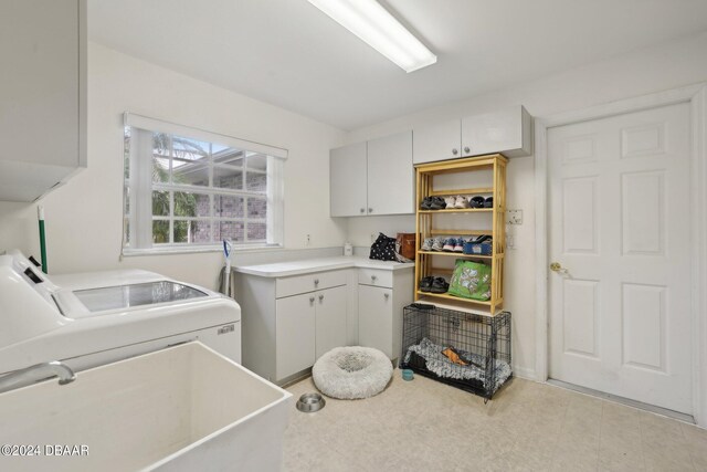 clothes washing area with sink, cabinets, and washing machine and clothes dryer