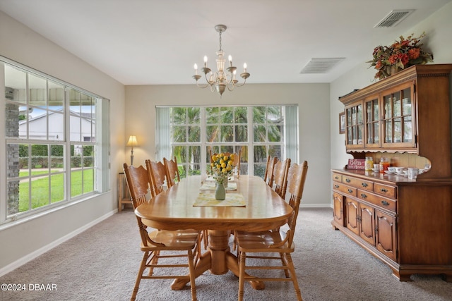 dining area featuring a wealth of natural light, light colored carpet, and a chandelier