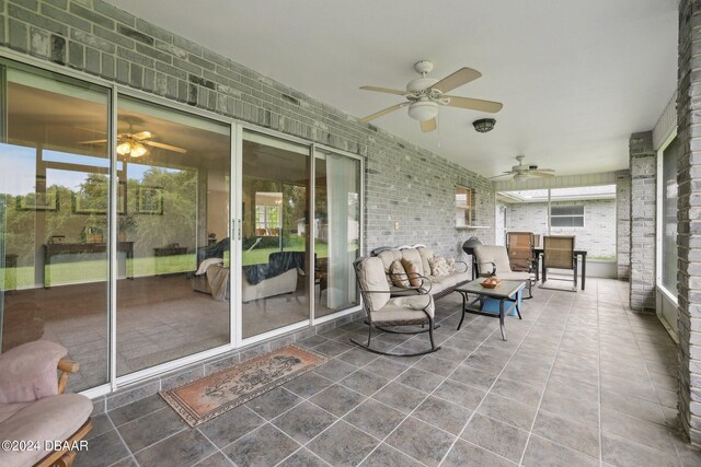 sunroom / solarium featuring a wealth of natural light and ceiling fan