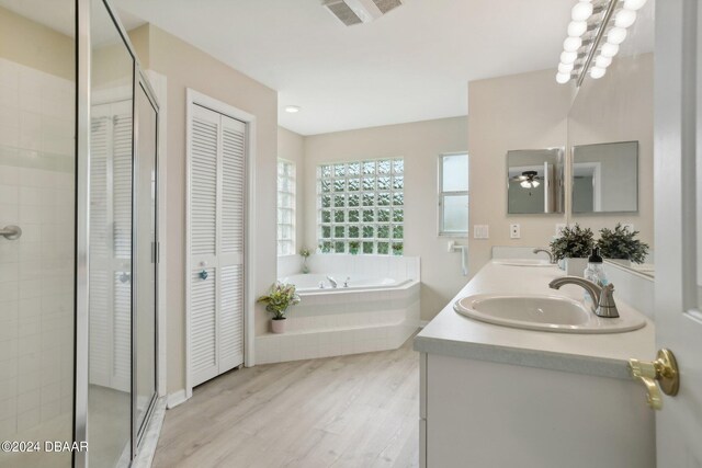 bathroom featuring hardwood / wood-style flooring, ceiling fan, vanity, and separate shower and tub