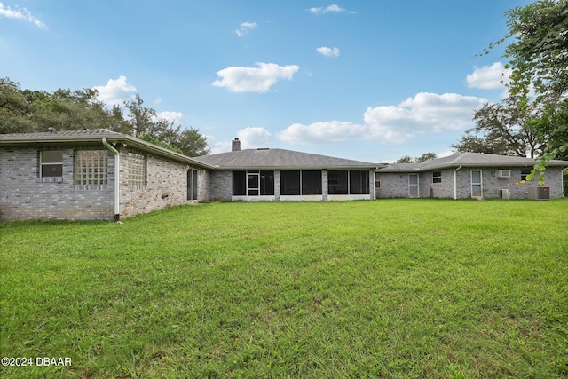 back of property featuring central AC, a lawn, and a sunroom