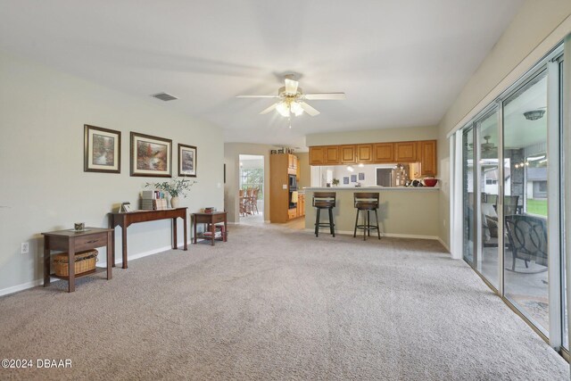 miscellaneous room with ceiling fan, plenty of natural light, and light colored carpet