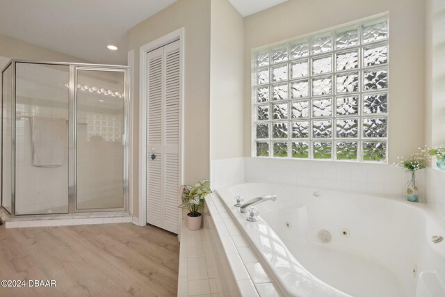 bathroom with plus walk in shower and hardwood / wood-style flooring