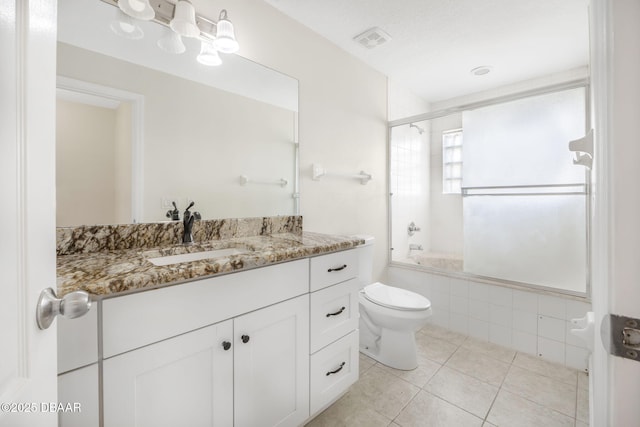 full bathroom featuring tile patterned flooring, tiled shower / bath, visible vents, toilet, and vanity