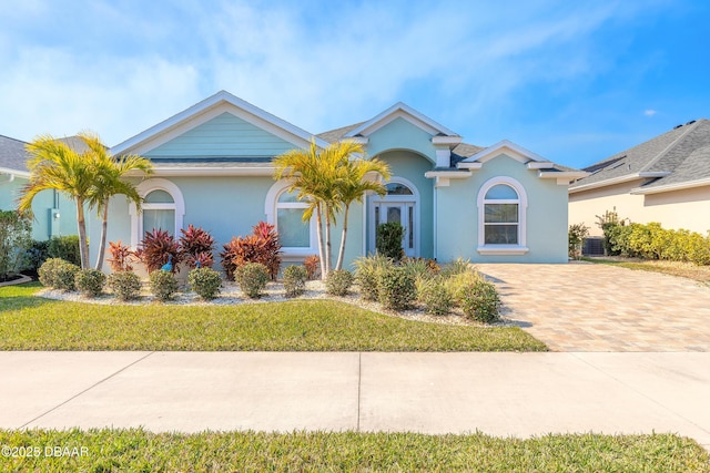 ranch-style home featuring central AC unit and a front lawn