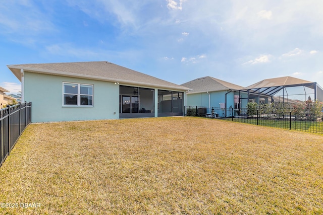 back of property featuring a lawn, a sunroom, and glass enclosure