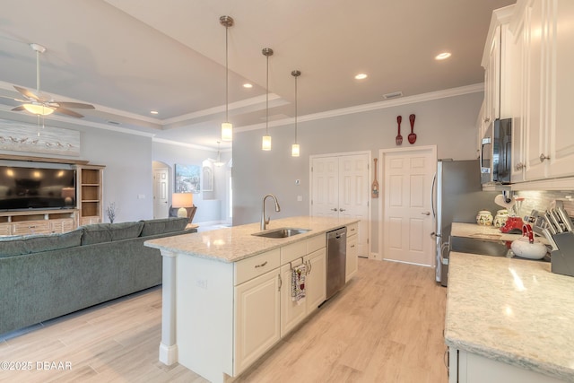 kitchen with stainless steel appliances, sink, a center island with sink, and white cabinets