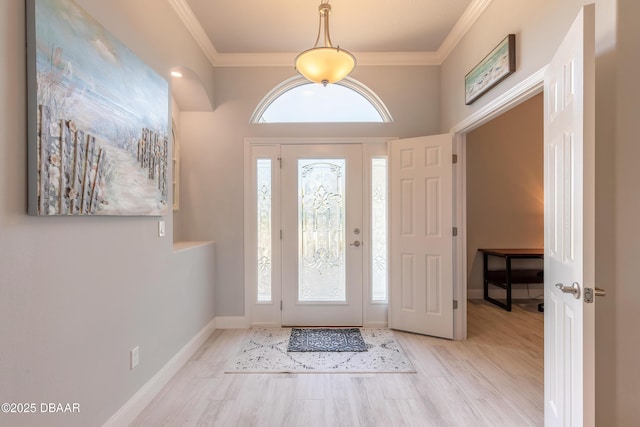 foyer entrance with light hardwood / wood-style flooring and ornamental molding