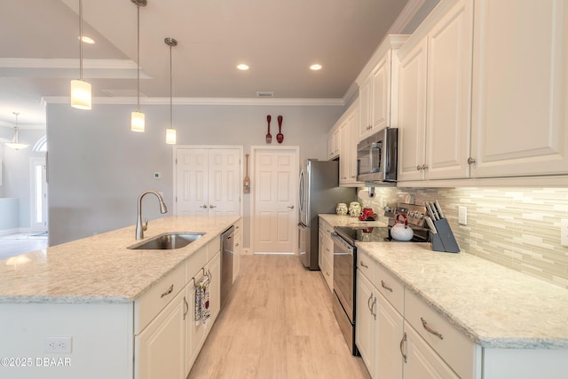 kitchen featuring an island with sink, appliances with stainless steel finishes, white cabinets, and decorative light fixtures