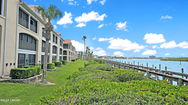 dock area featuring a water view and a lawn