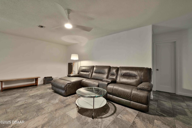 living room with a textured ceiling and ceiling fan