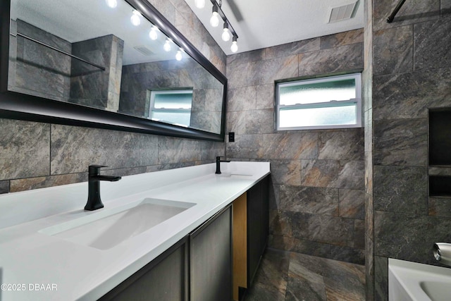 bathroom featuring vanity, shower / washtub combination, and tile walls