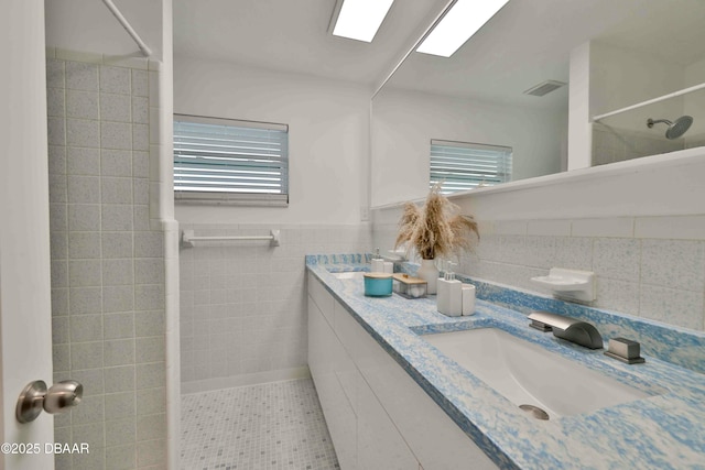 bathroom featuring vanity and tile walls