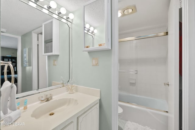 full bathroom with toilet, a textured ceiling, vanity, and combined bath / shower with glass door