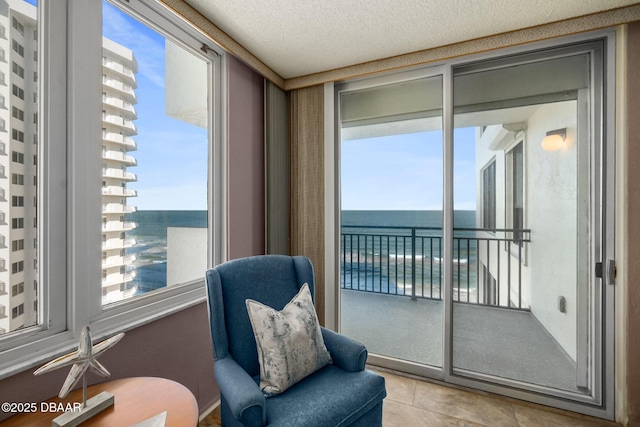2987 S Atlantic Ave Unit 805, Daytona Beach Shores, FL 32118 - sitting room featuring plenty of natural light, tile patterned flooring, a water view, and a textured ceiling
