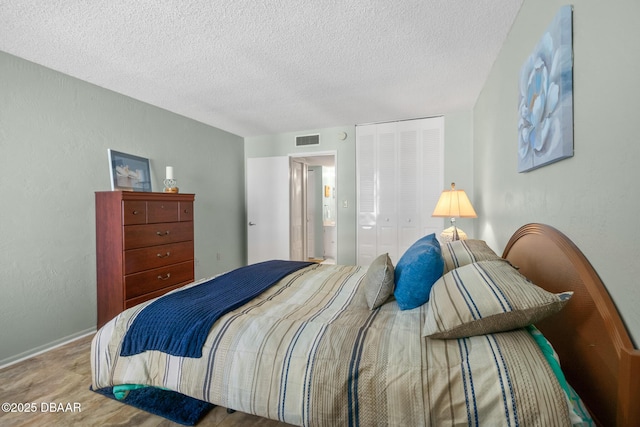 bedroom featuring a closet, a textured ceiling, and light colored carpet