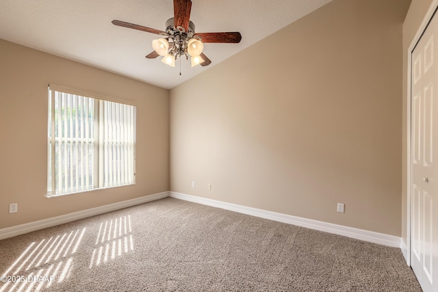 carpeted empty room featuring ceiling fan and lofted ceiling