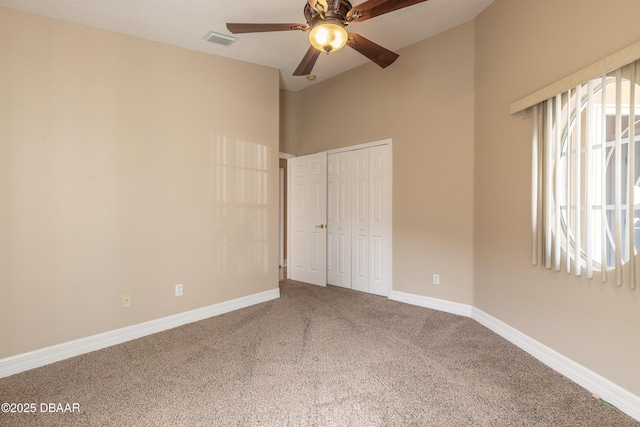 carpeted spare room featuring ceiling fan