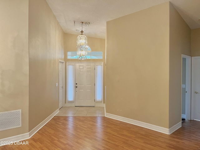 foyer entrance with a chandelier and light hardwood / wood-style floors