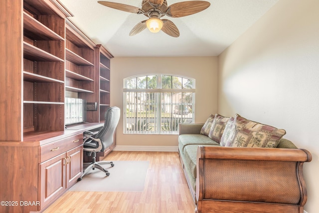 office featuring light hardwood / wood-style floors, ceiling fan, and built in desk