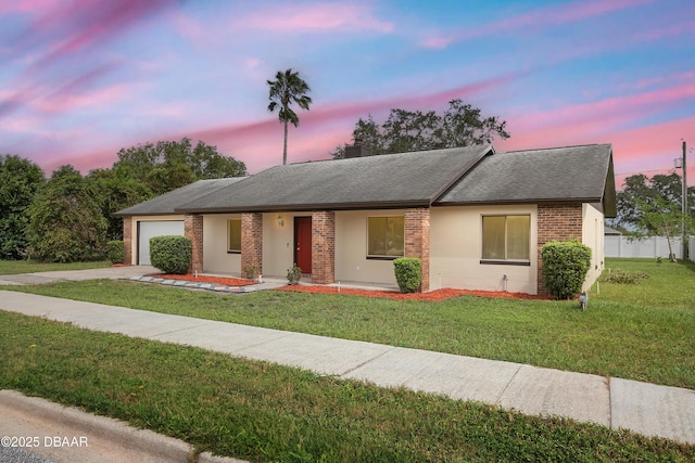 ranch-style home with a yard and a garage