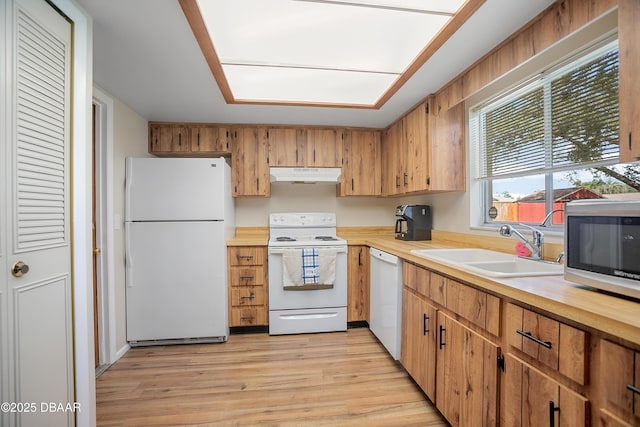 kitchen featuring white appliances, sink, and light wood-type flooring