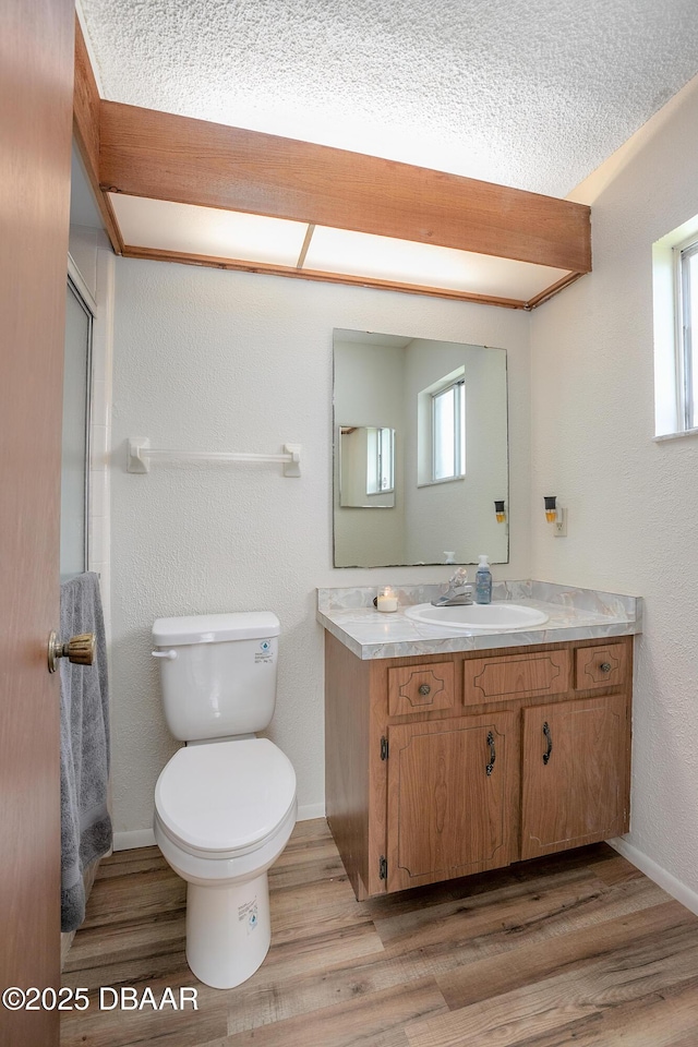 bathroom featuring hardwood / wood-style flooring, vanity, a textured ceiling, and toilet