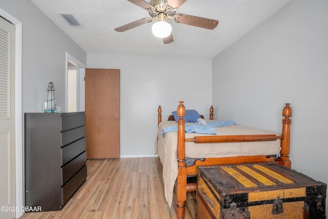 bedroom with wood-type flooring, ceiling fan, and a textured ceiling