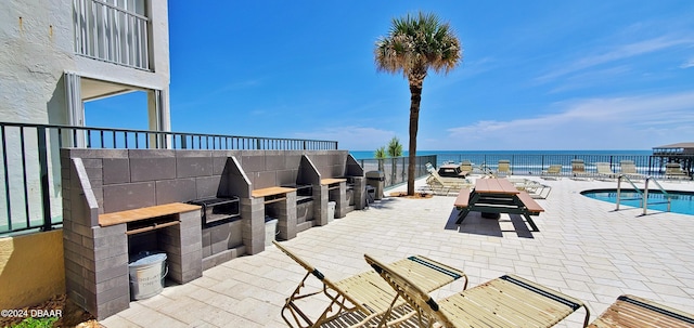 view of patio / terrace with a water view and a community pool