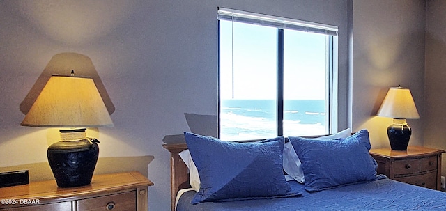 bedroom with multiple windows and a water view