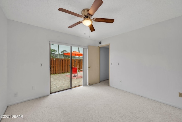 carpeted spare room featuring a textured ceiling and ceiling fan