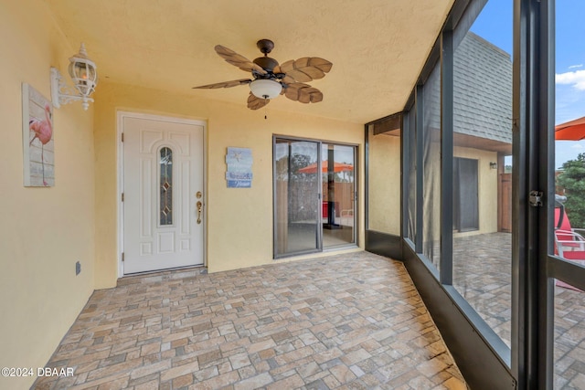 unfurnished sunroom with ceiling fan