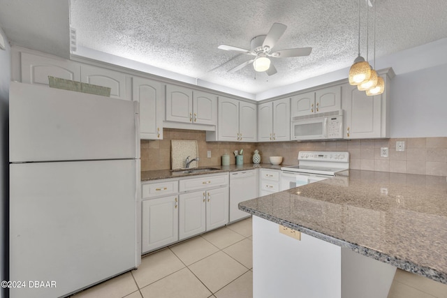 kitchen featuring pendant lighting, white appliances, sink, and backsplash