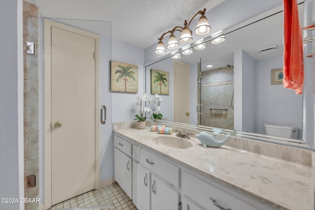 bathroom with walk in shower, vanity, a textured ceiling, and tile patterned floors