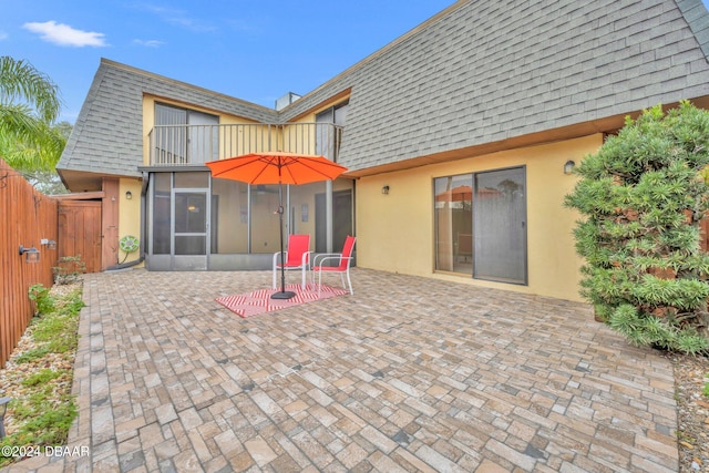 back of property featuring a balcony and a patio area