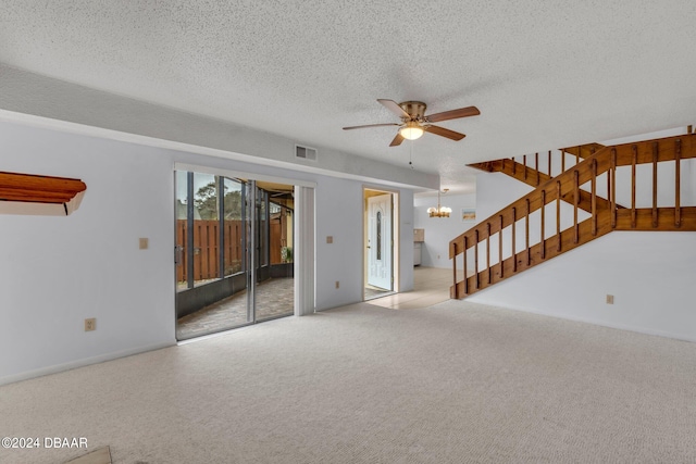 interior space featuring ceiling fan with notable chandelier, a textured ceiling, and light carpet