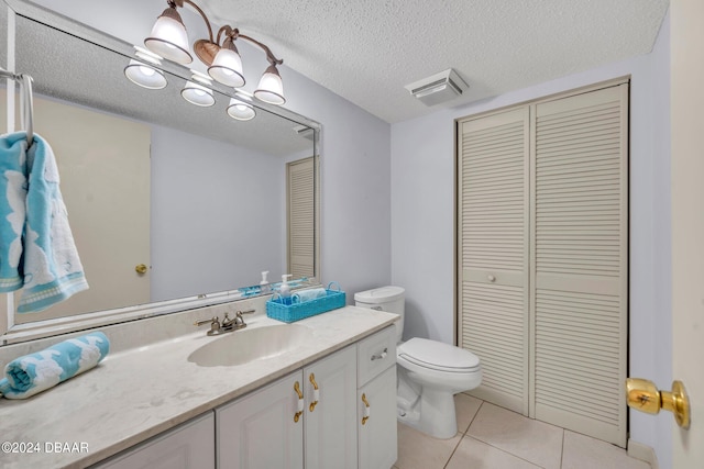 bathroom featuring vanity, tile patterned flooring, toilet, and a textured ceiling