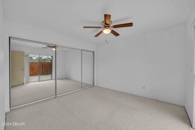 unfurnished bedroom featuring a closet, light colored carpet, and ceiling fan