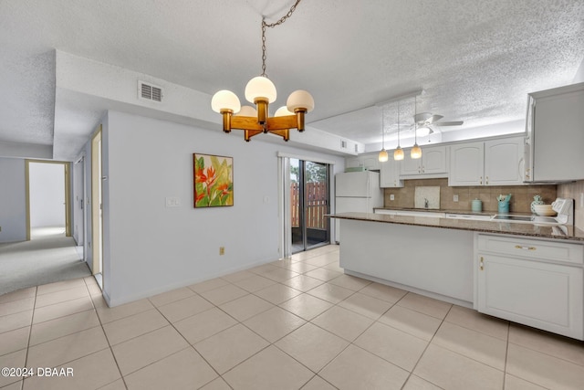 kitchen featuring white cabinetry, ceiling fan with notable chandelier, a textured ceiling, light tile patterned floors, and decorative light fixtures