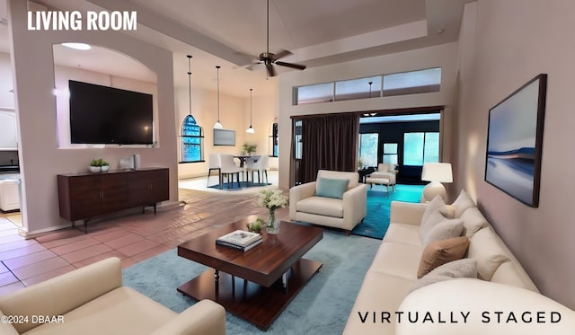 tiled living room featuring ceiling fan and a towering ceiling