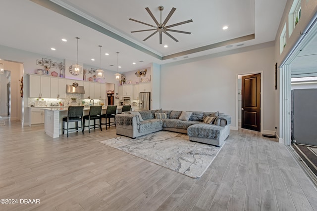 6232 W Fallsgrove Ln, Port Orange, FL 32128 - living room featuring a raised ceiling, ceiling fan, and light hardwood / wood-style flooring