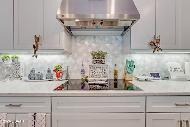 6232 W Fallsgrove Ln, Port Orange, FL 32128 - kitchen featuring light stone counters, exhaust hood, tasteful backsplash, and black electric stovetop