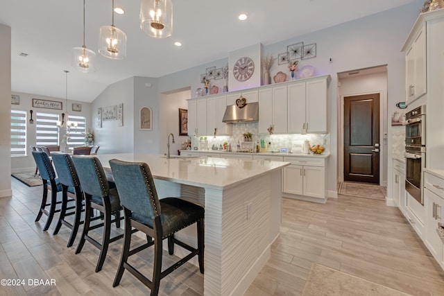 6232 W Fallsgrove Ln, Port Orange, FL 32128 - kitchen featuring an island with sink, hanging light fixtures, range hood, and vaulted ceiling