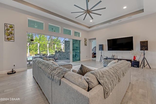 6232 W Fallsgrove Ln, Port Orange, FL 32128 - living room with ceiling fan, a raised ceiling, light hardwood / wood-style flooring, and ornamental molding